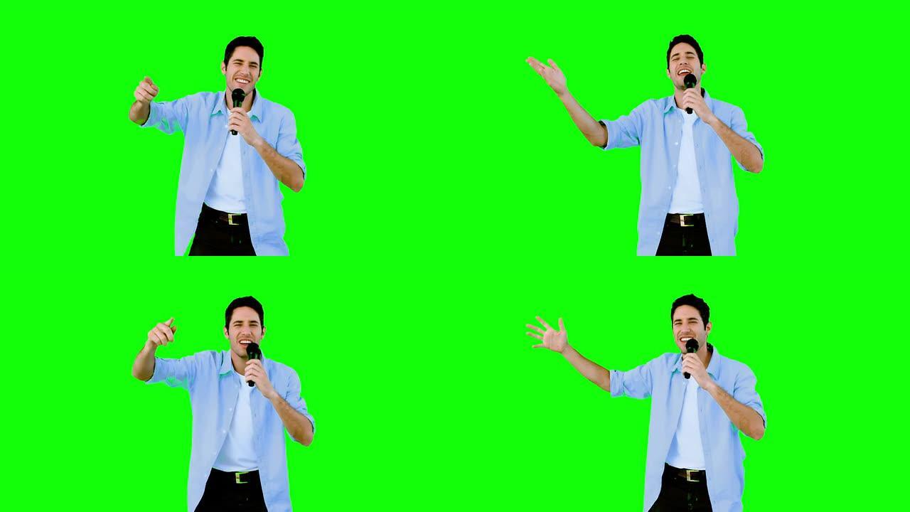 男子在绿色屏幕上对着麦克风唱歌