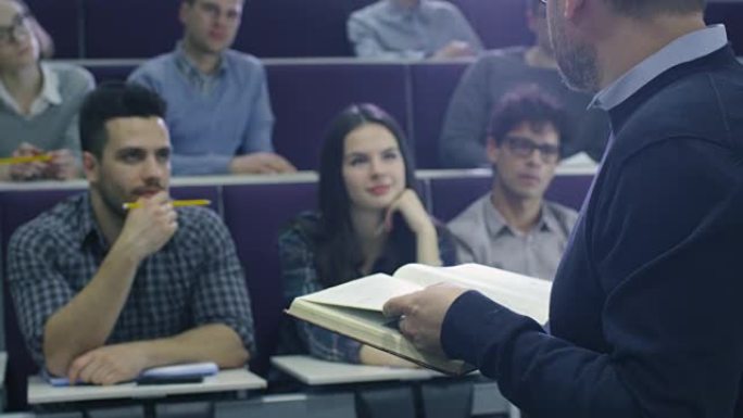 大学教授正在教授一班多民族学生，同时拿着一本书。