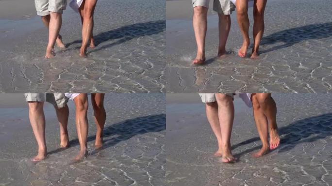 南非海滩上，夫妻的双腿在水中行走的慢动作镜头