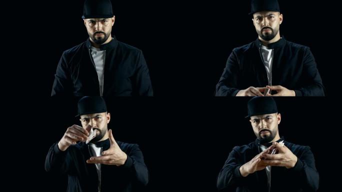 戴着帽子的专业街头魔术师表演手牌技巧。在空中投掷和捕捉卡片。背景是黑色的。慢动作。