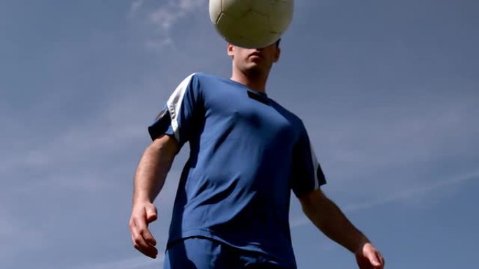足球运动员在蓝天下控制球