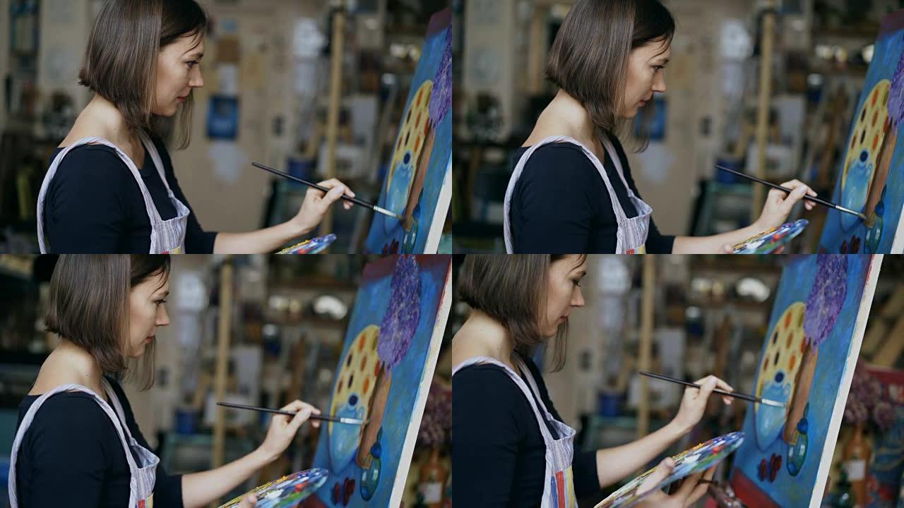 年轻艺术家女人在艺术学校的画布上画静物画