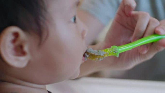 亚洲男婴 (6-11个月) 在家吃婴儿食品