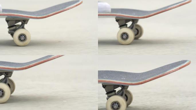 慢动作dop: 滑板运动员站在甲板上，滑板轮旋转