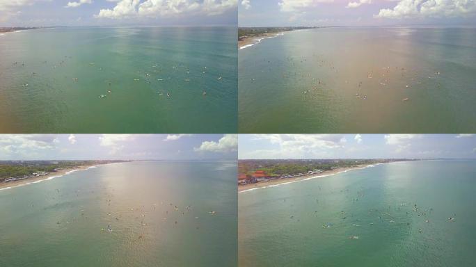 空中镜头耀斑: 巴厘岛长谷的沙滩上拥挤的冲浪者