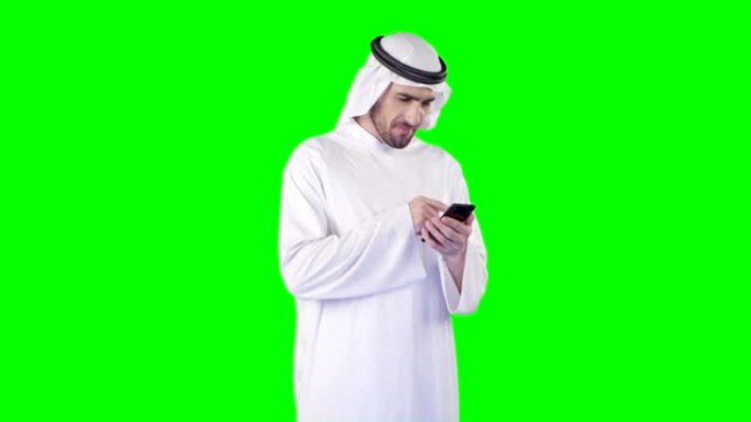 中东族裔男子在绿屏上使用智能手机。阿尔法，可循环