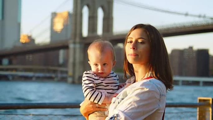 年轻的母亲和女儿站在曼哈顿的桥边