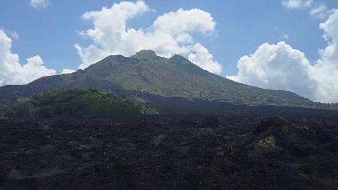 空中: 杂草丛生的巴图尔火山火山口脚下的黑色熔岩