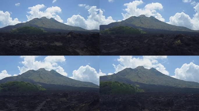 空中: 杂草丛生的巴图尔火山火山口脚下的黑色熔岩