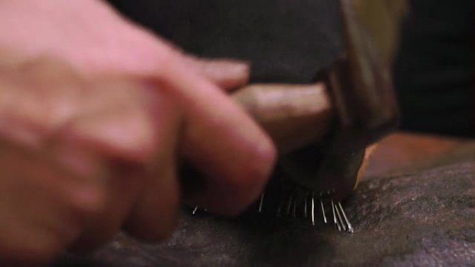 定制鞋匠将皮革钉在一起制成鞋子