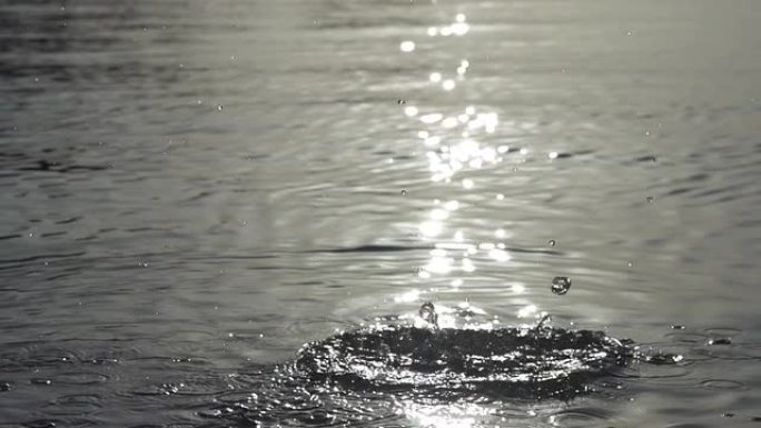 慢动作: 石头扔进水中，太阳反射
