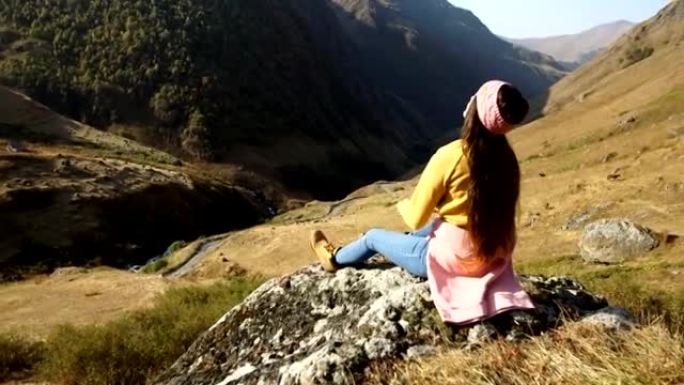 山地冒险。在岩石上休息的年轻女子