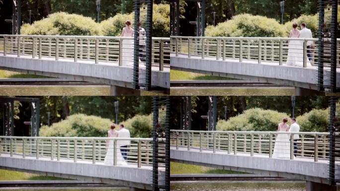 婚礼当天，幸福的夫妇走在桥上。美丽的新娘和新郎手牵手的背景图。Steadicam射击