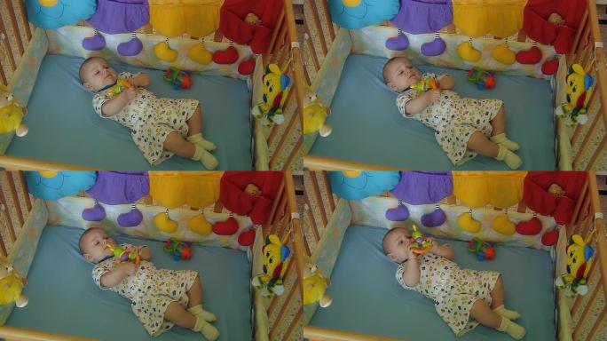 婴儿躺在婴儿床上，手里拿着一个玩具