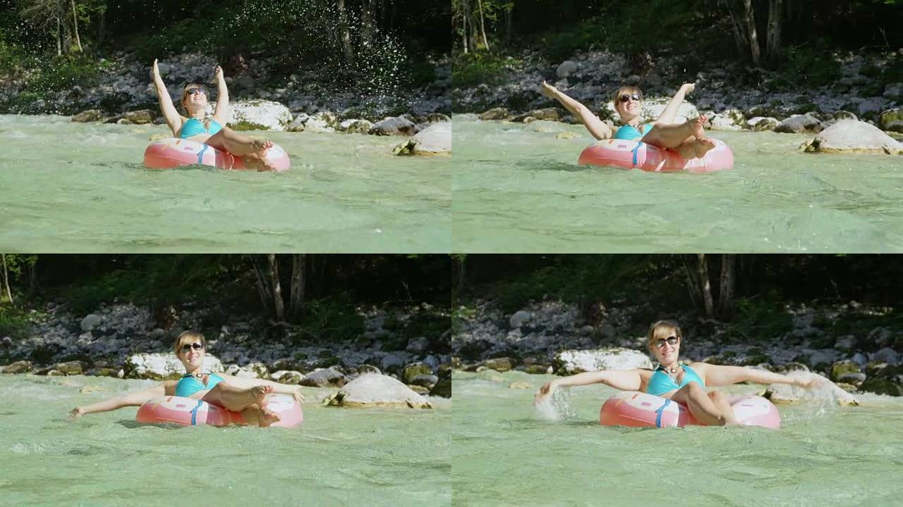 慢动作河滑翔女孩在甜甜圈漂浮物上溅水在空中