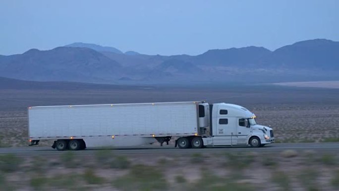 特写: 货运半卡车在空旷的高速公路上驾驶和运输货物