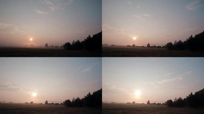 日出时的乡村场景，薄雾慢慢远离草地。太阳升起时会更加明亮。延时