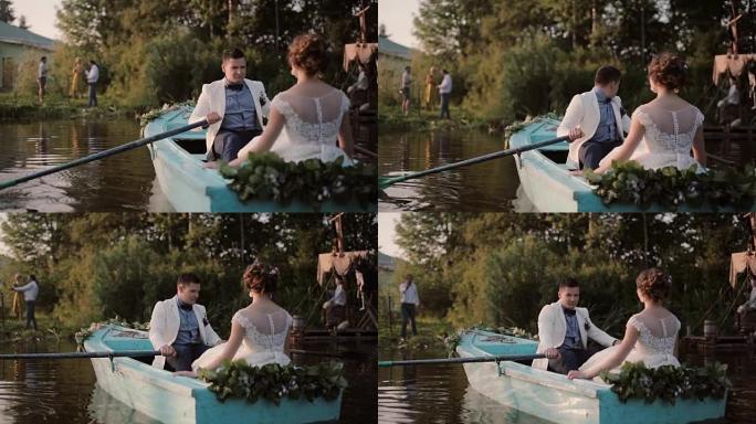 恋人在结婚那天玩得很开心。一对恋爱在一艘停泊在河岸的蓝色船上。新郎桨