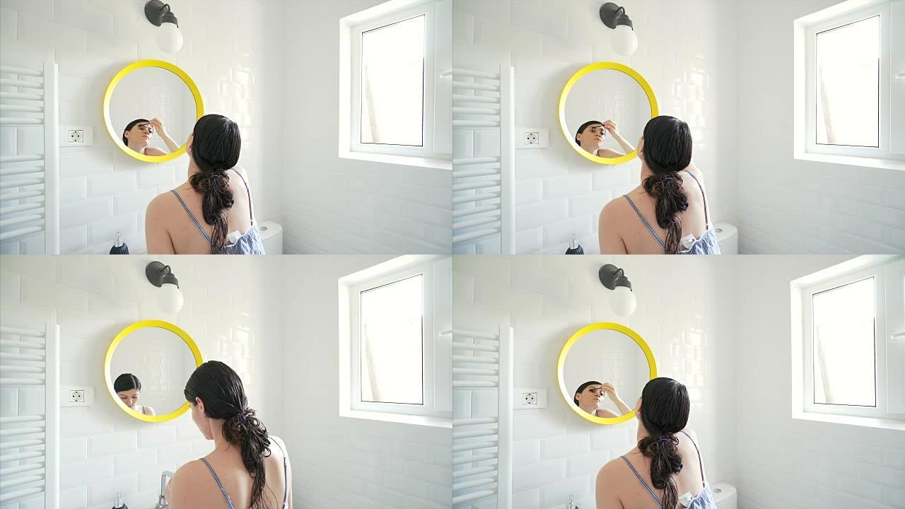 美女在浴室涂睫毛膏。