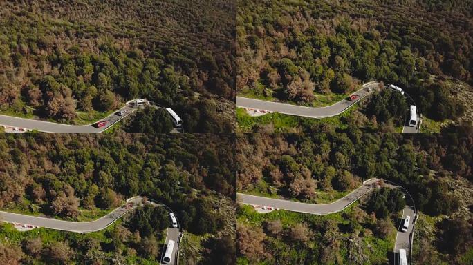 无人机在山路和车辆上倾斜。惊人的夏季蛇形鸟瞰图与公共汽车，货车和两辆车。4K