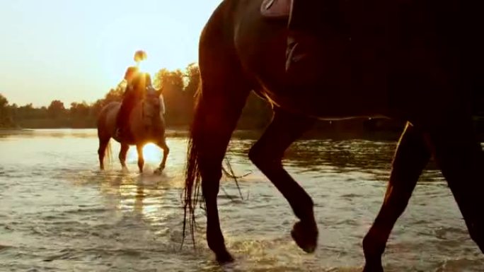 特写: 年轻女孩在金色日出时在河岸骑马