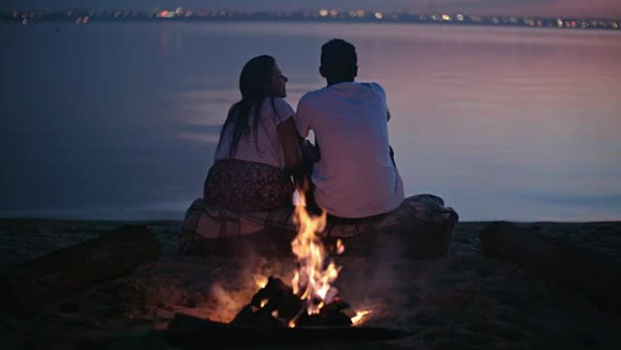 黄昏时在海滩上欣赏风景的夫妇