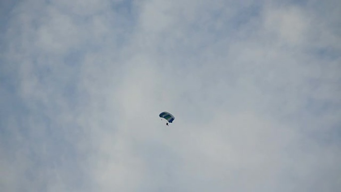 在蓝天白云中跳伞。
