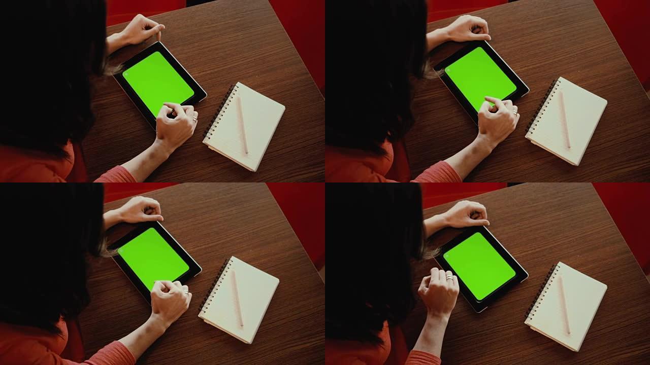 在平板电脑、笔记本上工作的女人。绿屏