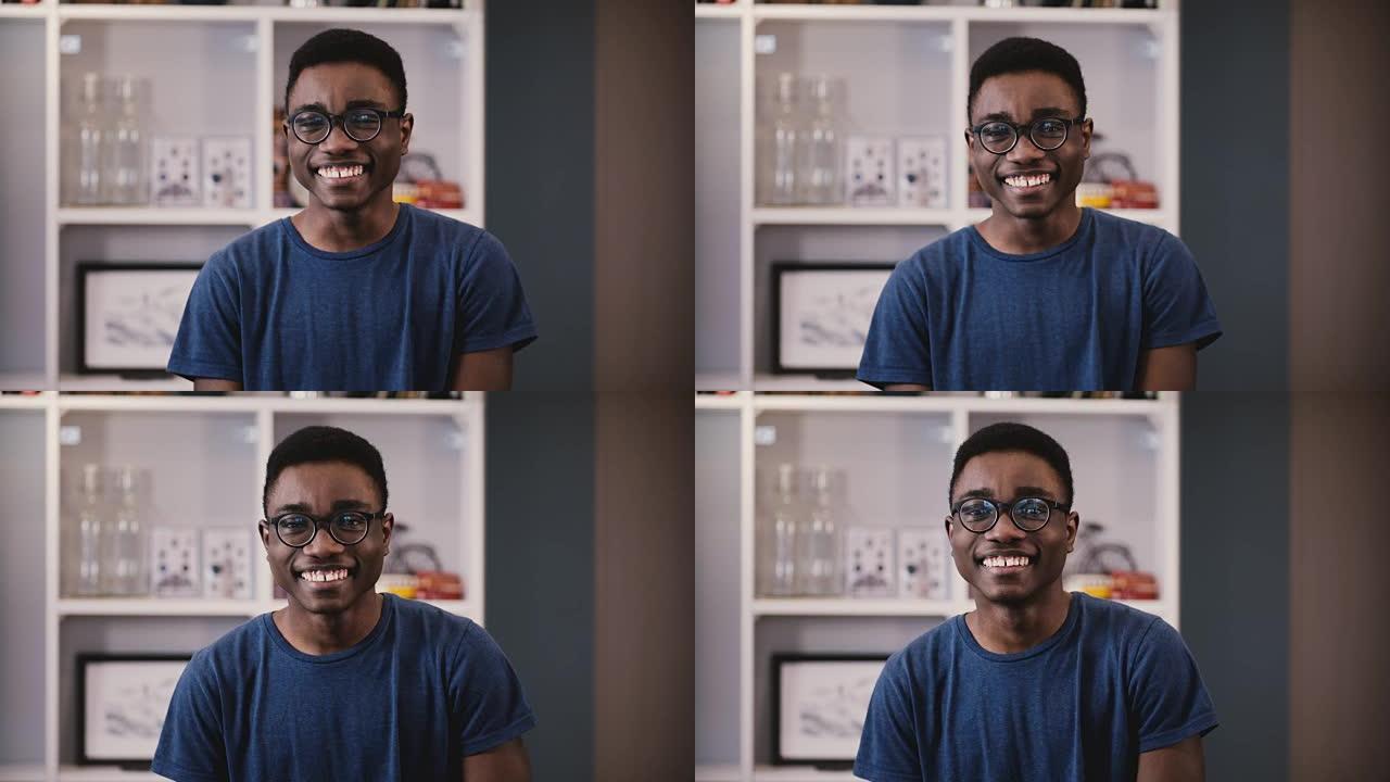 快乐的非洲裔美国商人看着相机。戴着眼镜的英俊黑人年轻人快乐地微笑。学生。4K