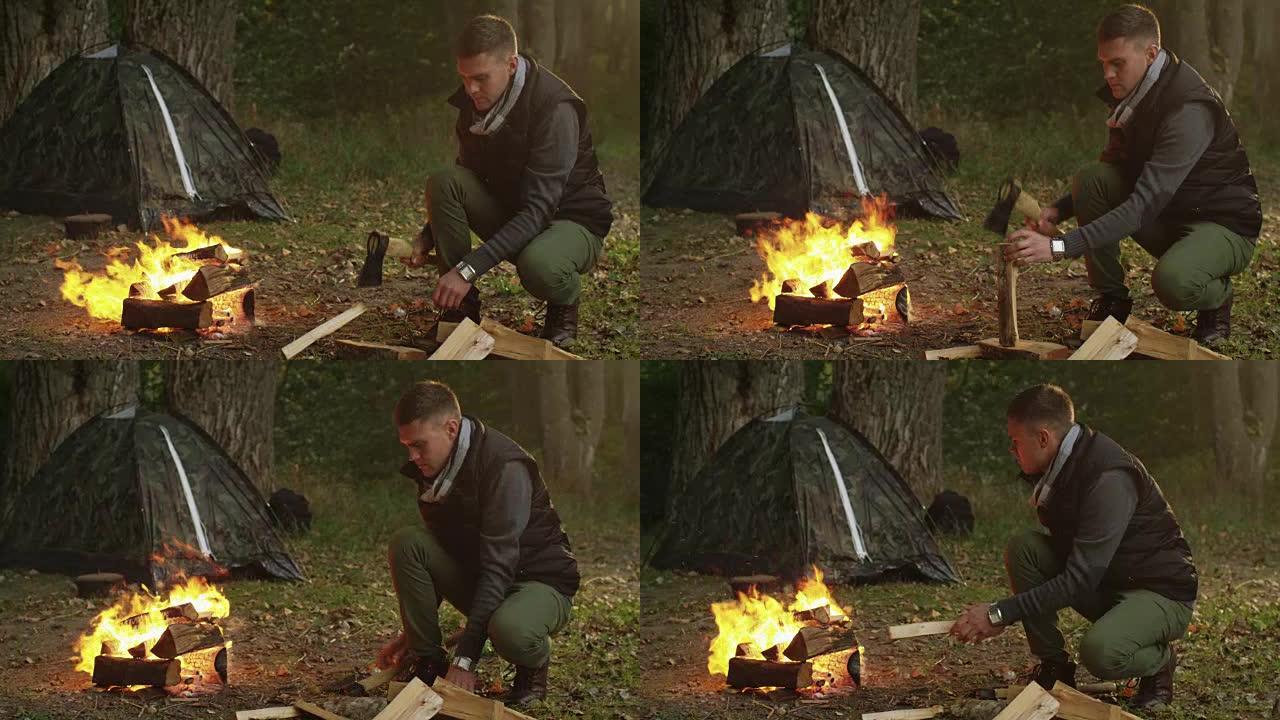穿着秋衣的短发男子正在用斧头砍柴并将其扔进火中。
