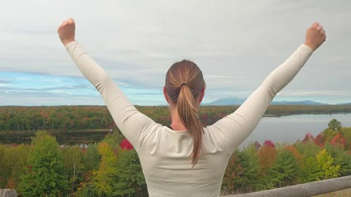 特写: 年轻女子举起手臂俯瞰迷人的秋天风景