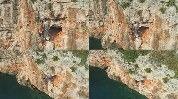 4k无人机视点男子在海洋上的阳光悬崖上攀岩，实时