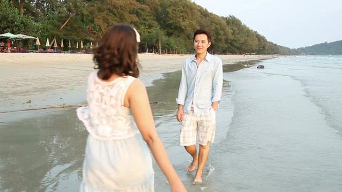 Dolly Shot:浪漫情侣在海滩日落时散步