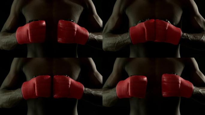 坚韧的拳击手用红色手套猛击拳头