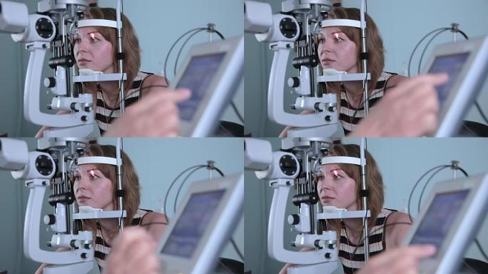 现代医疗程序。眼科医生在眼睛检查时将其指向触摸屏