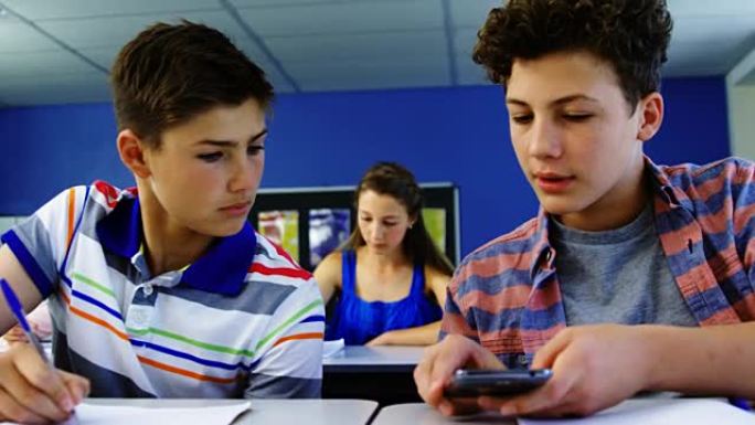 学生在教室里使用手机