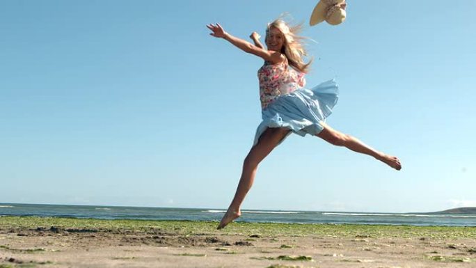 迷人的金发女郎在海滩上跳芭蕾舞