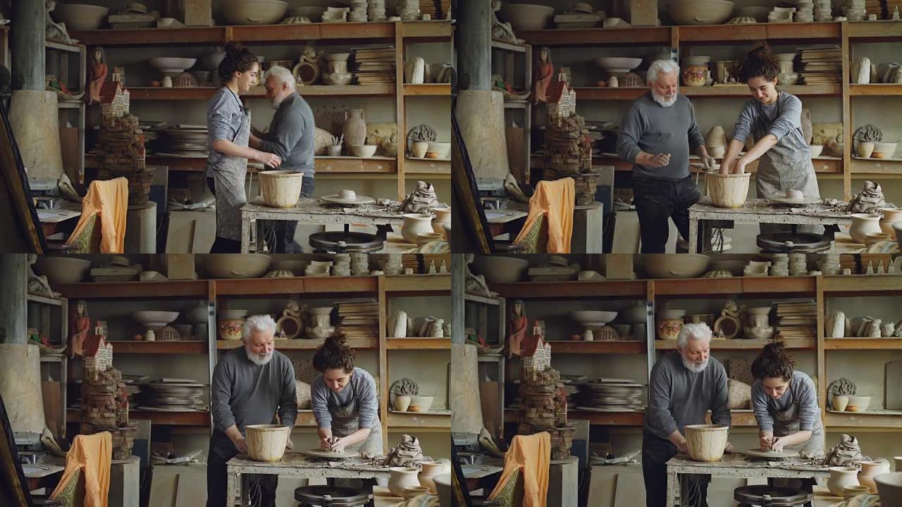 有爱心的高级祖父正在向年轻的祖父展示如何在车间的投掷轮上使用黏土。陶器、家庭爱好和手工艺概念