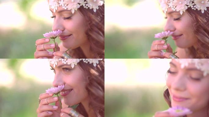 波西米亚风格的女孩在大自然中闻到一朵鲜花