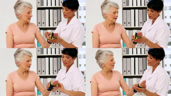 护士向老年患者展示如何戴上手腕支架