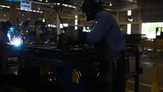 在汽车零部件行业使用焊接机的工人。