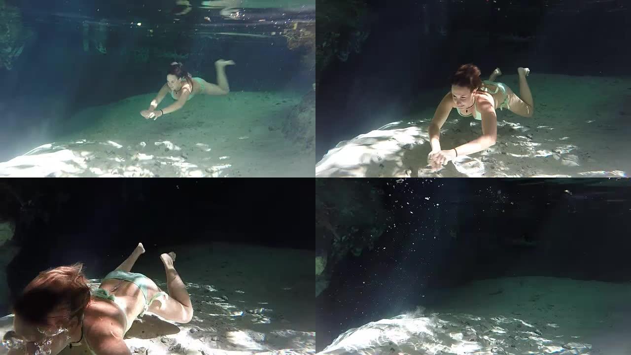 水下: 美丽的年轻女子探索地下水中的cenote洞穴潜水