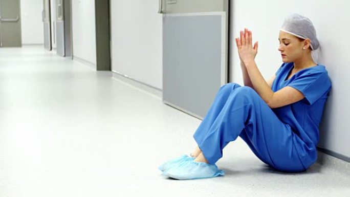 悲伤的护士坐在地板上