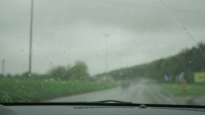 特写: 擦拭高速公路上汽车挡风玻璃上的雨滴