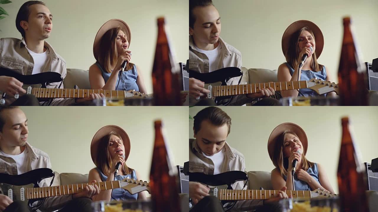 漂亮的年轻女子正在唱歌，她英俊的朋友吉他手在尼斯光工作室排练时正在演奏电吉他。创意二重唱概念。