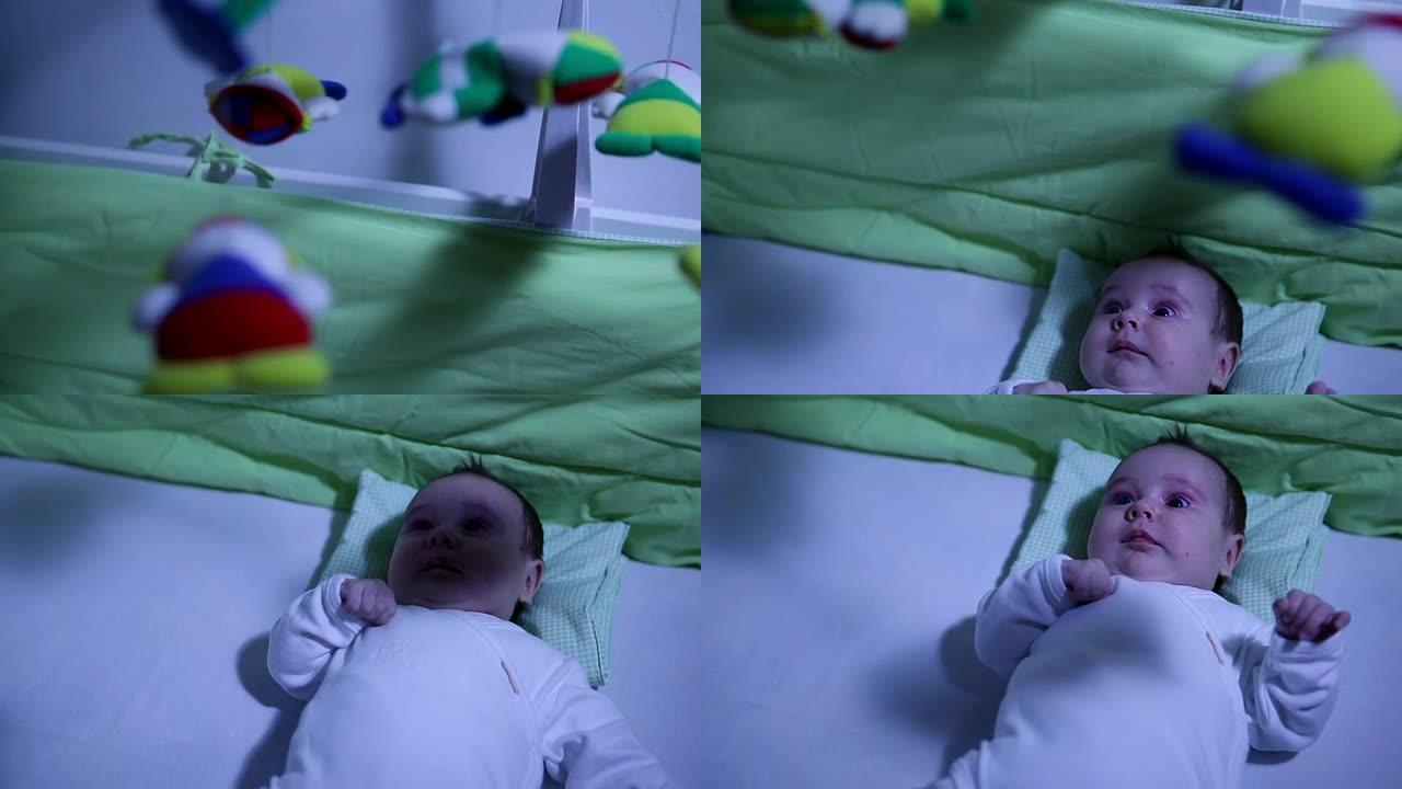 女婴在晚上的婴儿床与移动