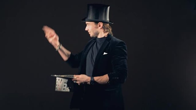 一位男性巫师正在玩纸牌并将其变成帽子