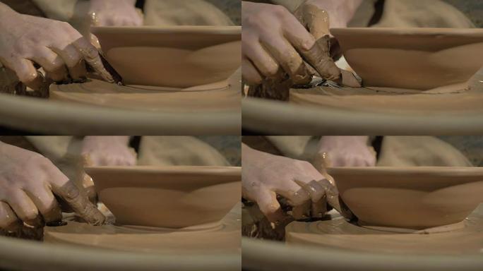 男性陶艺家的手在轮子上做碗。