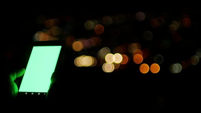 绿屏智能手机和城市的bokeh circle灯光背景