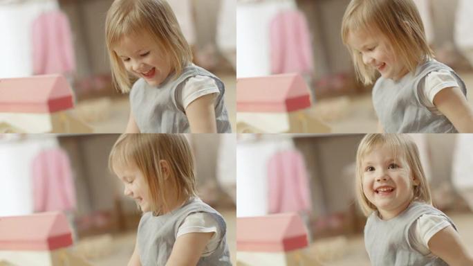 快乐的小女孩坐在她的房间里，对着镜头微笑。慢动作。